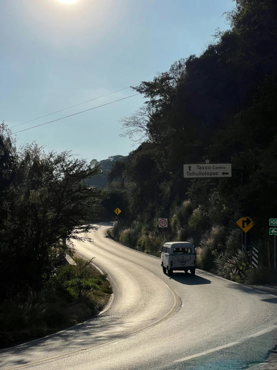 a white truck driving down the middle of a hill