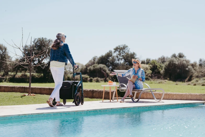 a woman hing her walker next to another women in the sun