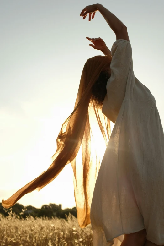 the woman is reaching for the frisbee in the sky