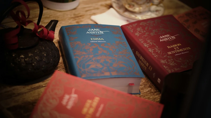 three small red and blue book on the table