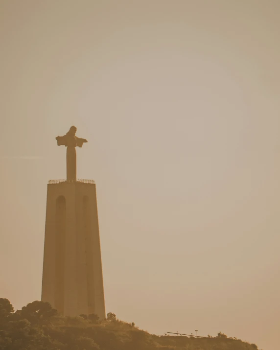 a tall tower with a statue atop it