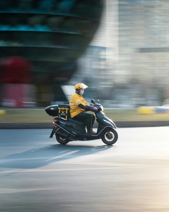 man wearing yellow riding on a black motorcycle