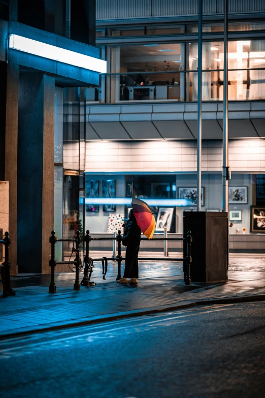 person standing with umbrella at a bus stop in the rain