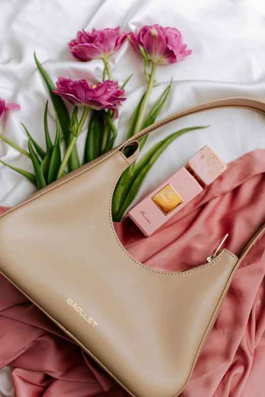 a woman's handbag on top of a pink cloth