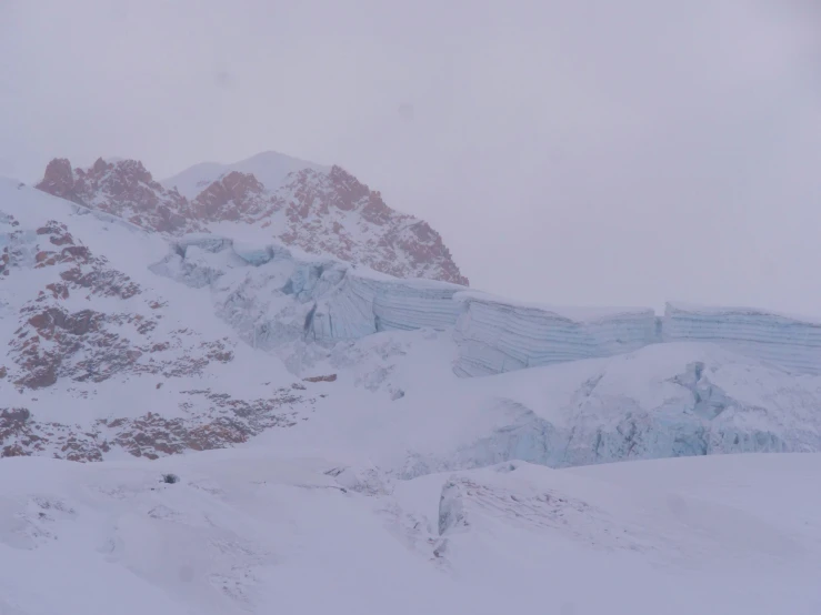 a mountain slope covered in snow with a ski lift going down it