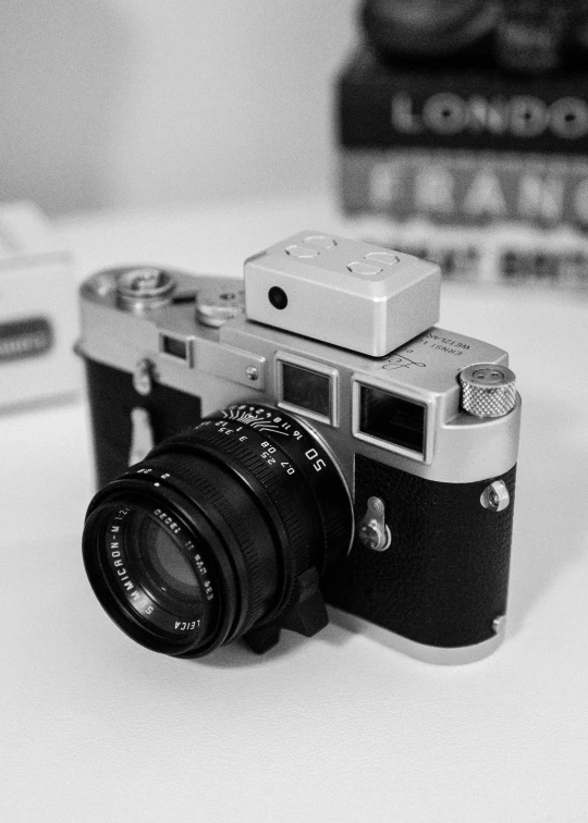 old camera sits on the desk with books behind it