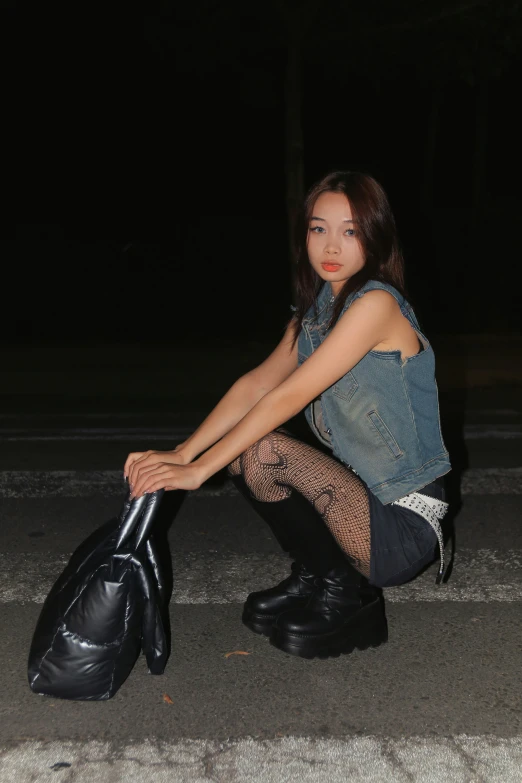 young woman in black tights sitting on curb at night