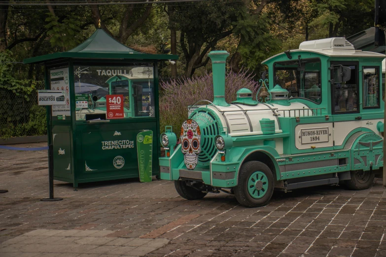 a green and white bus is parked next to the telephone booth