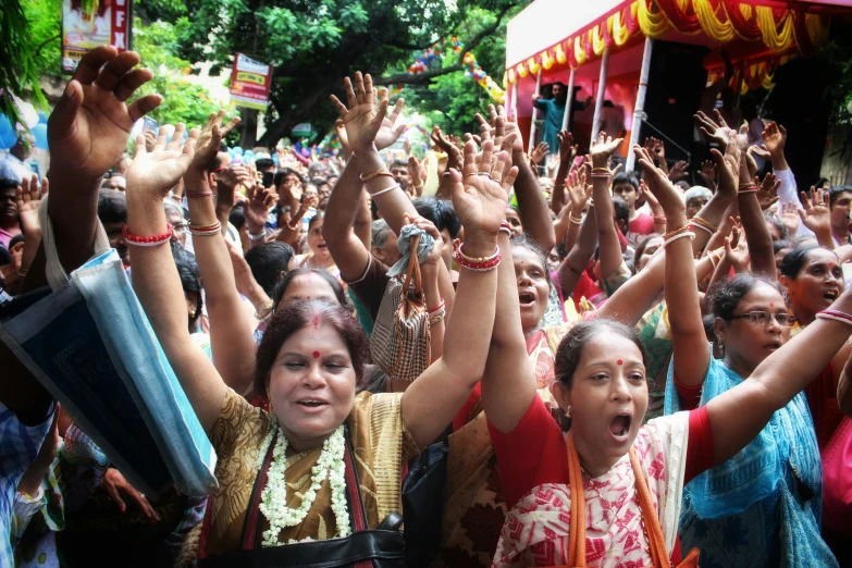 many people raising their hands together to show enthusiasm