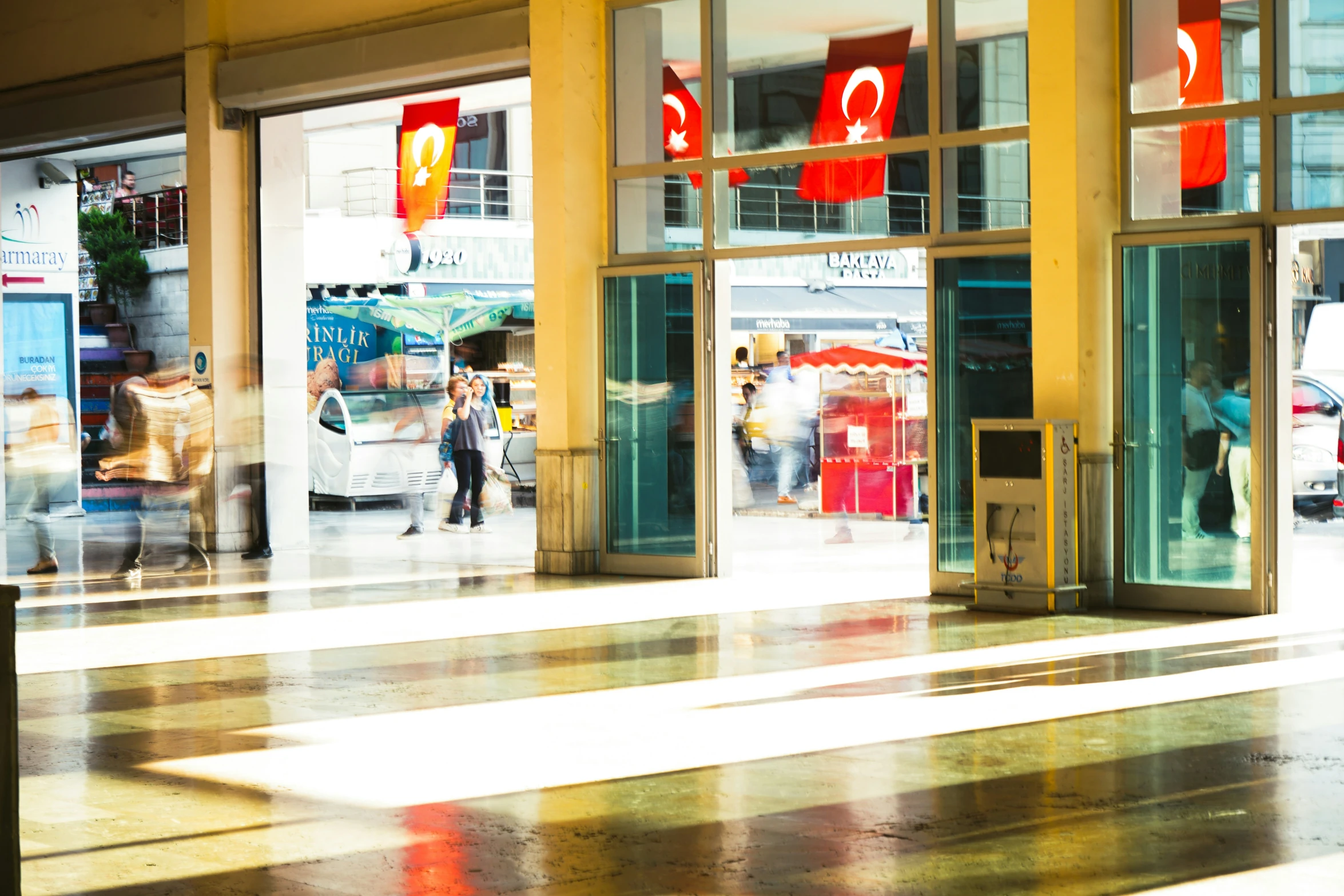 a store front with lots of windows and people walking on the sidewalk