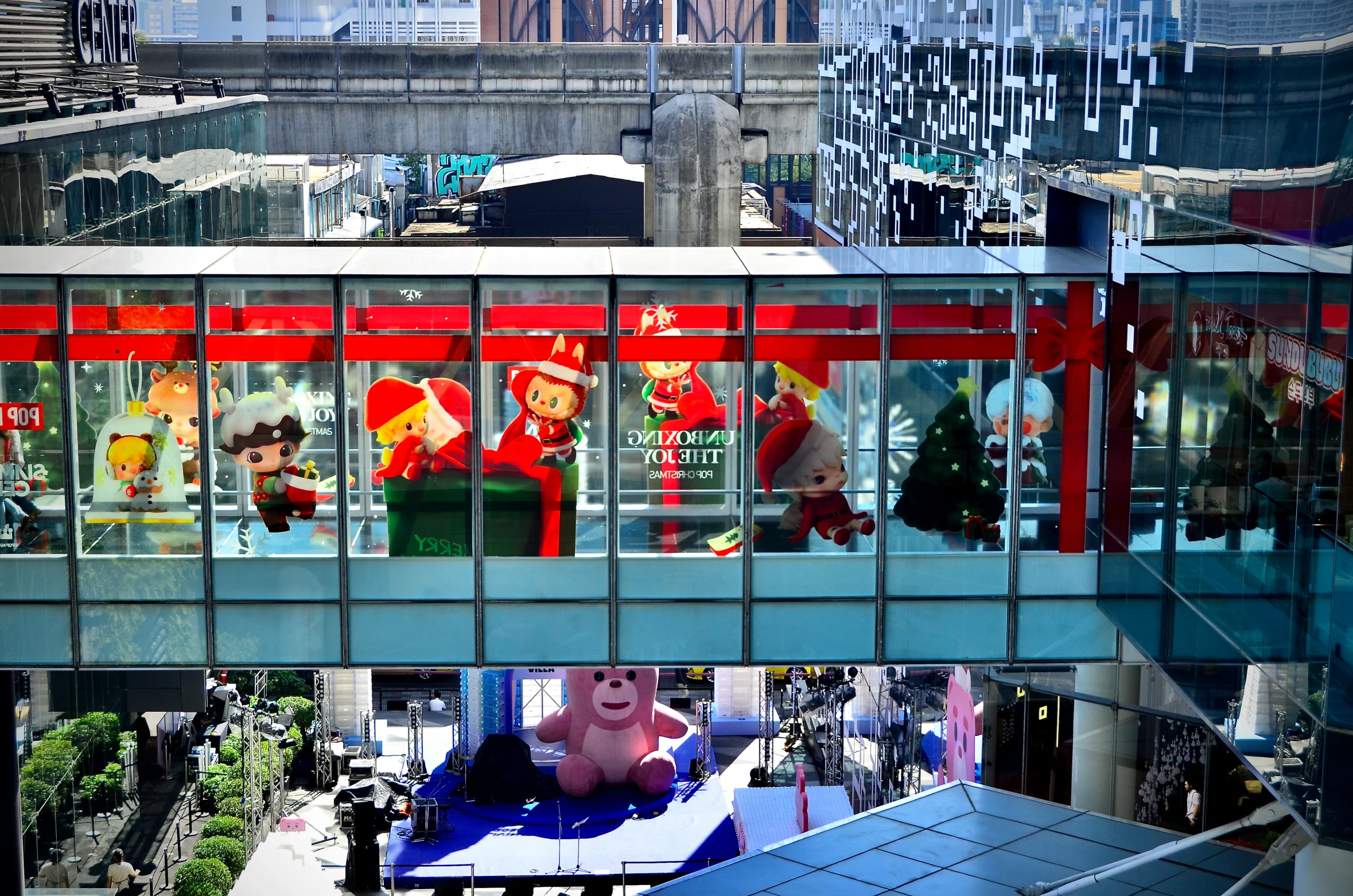 the reflection of people on the glass wall of the pedestrian bridge