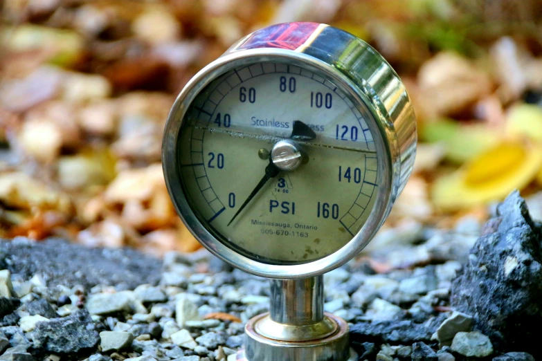 a meter sitting on a gravel patch