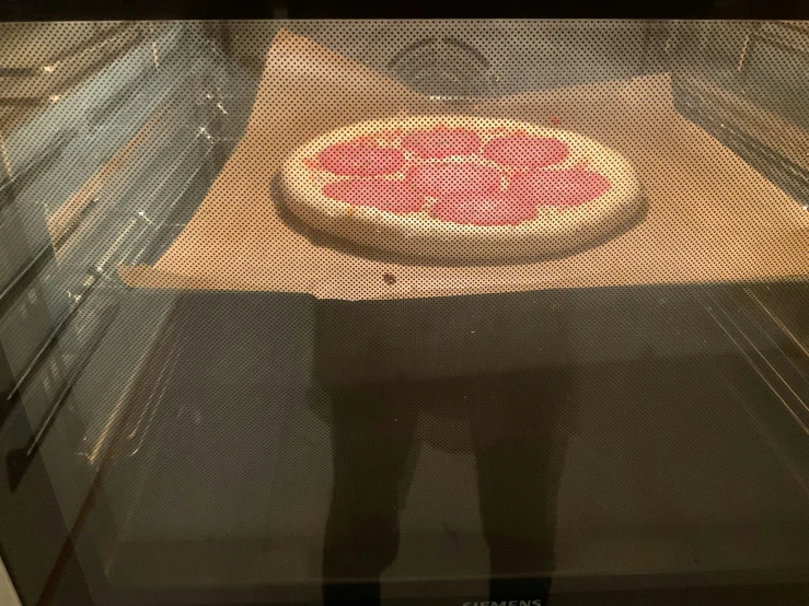 a man standing in front of a glass oven door