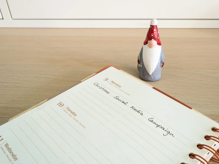 an open note pad sitting on top of a wooden desk