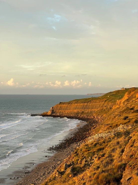 view from hillside looking down at rocky shoreline and large body of water