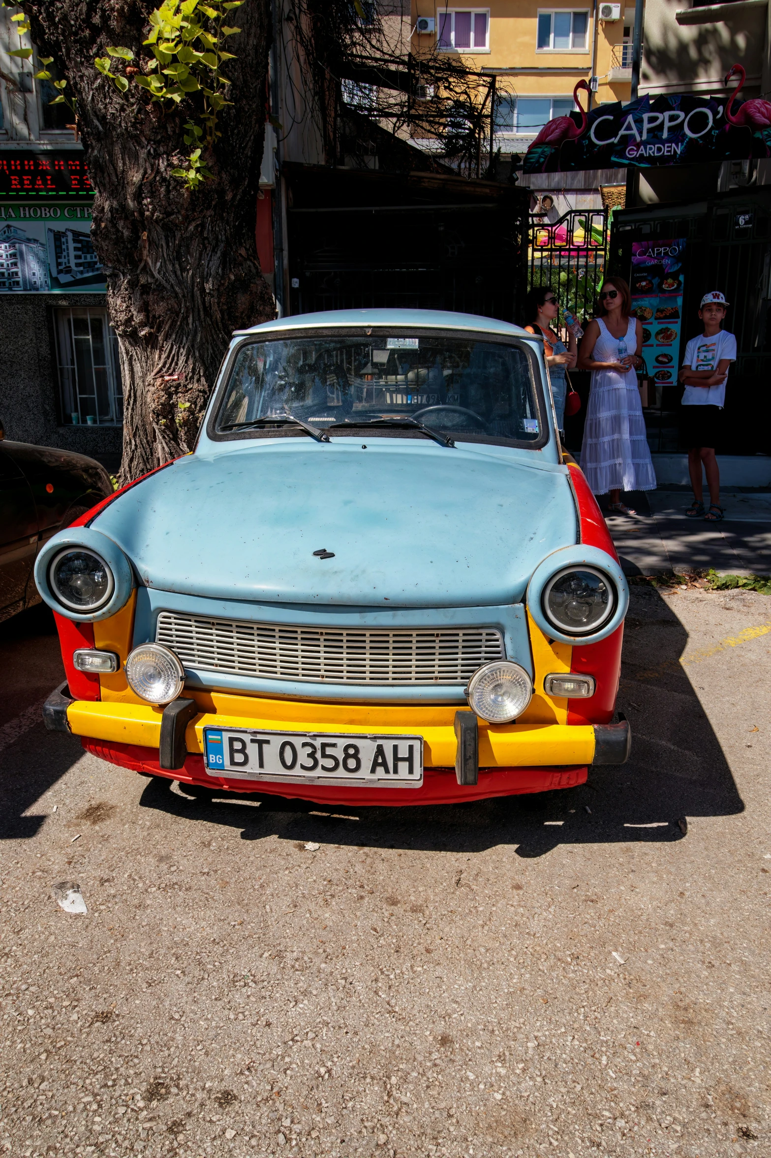 an old car with a blue hood parked in front of another car