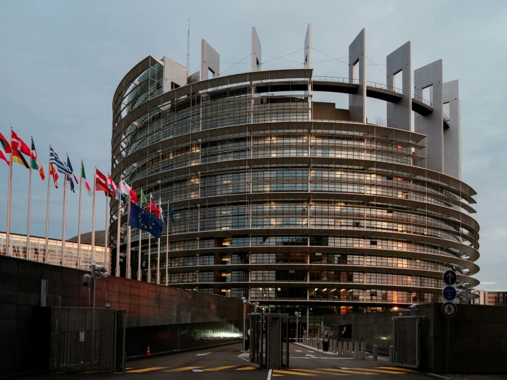 a large circular building has flags outside