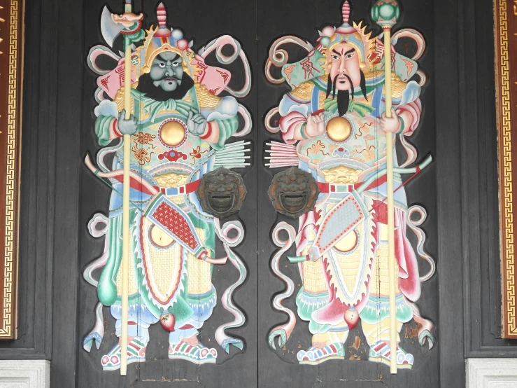 two wooden statues on the side of a door