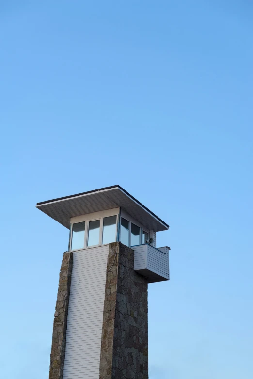 an air traffic control tower in front of a blue sky