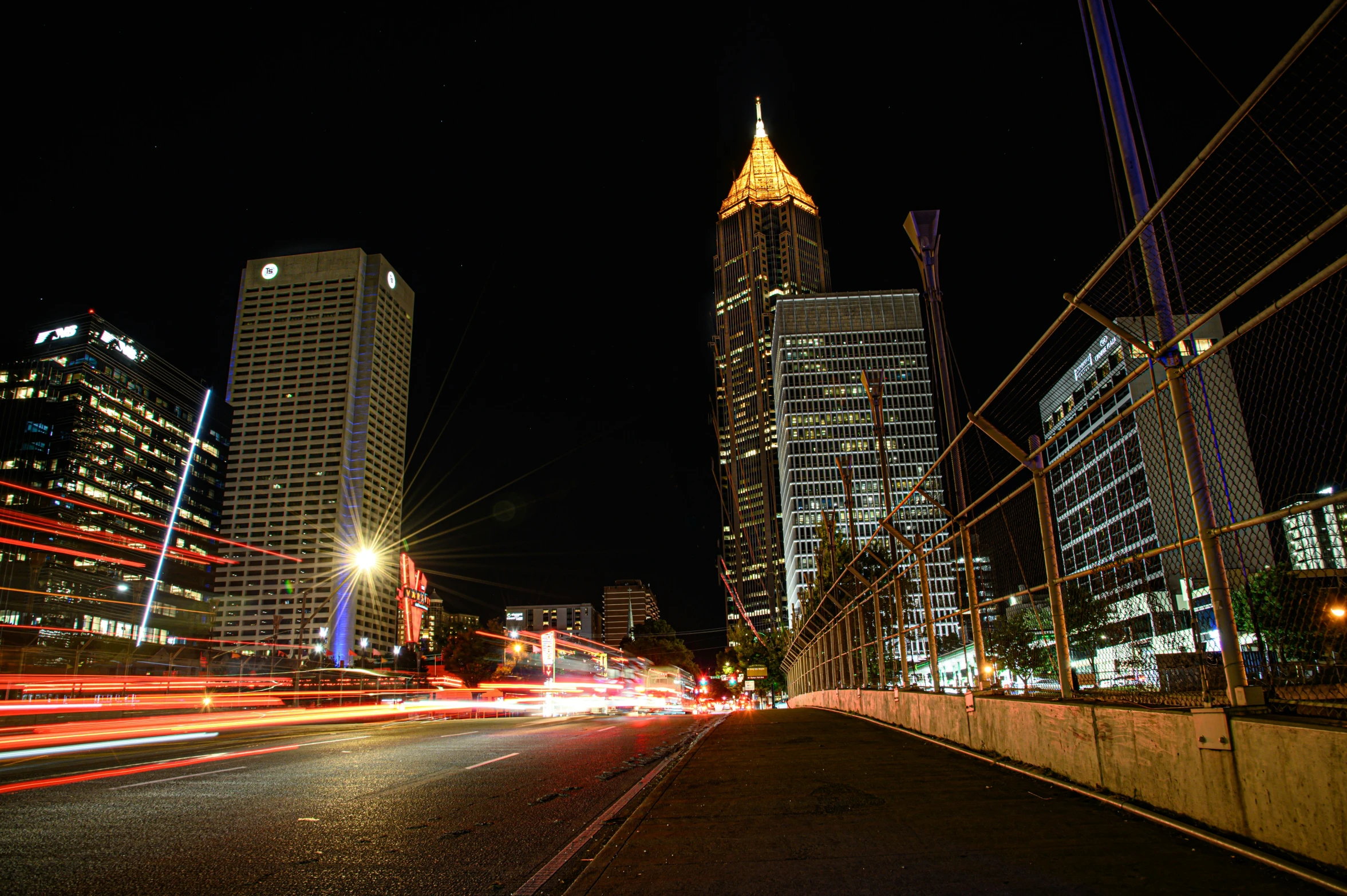 a street with lights on and buildings in the background