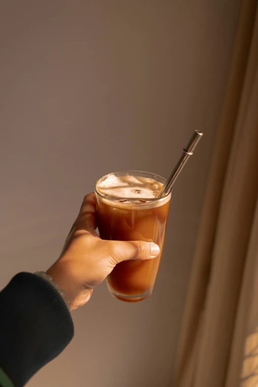 a hand holding a drink up to the camera