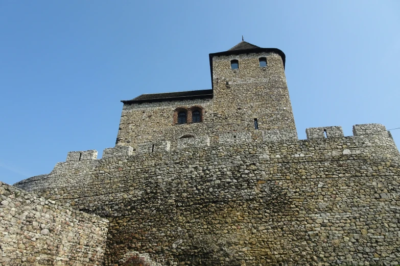 the large stone tower has two towers on one side