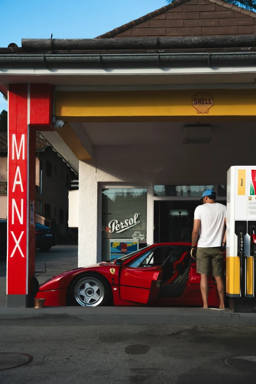 a man standing next to a parked red sports car