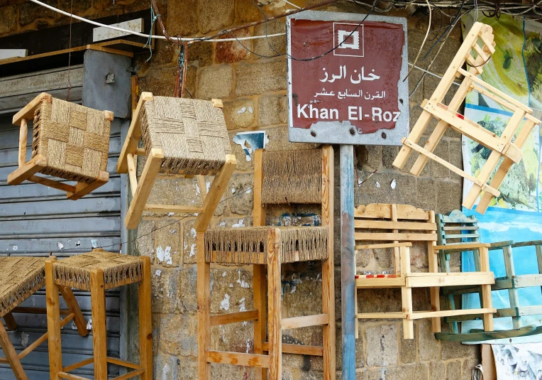 some wooden chairs that are by some wall