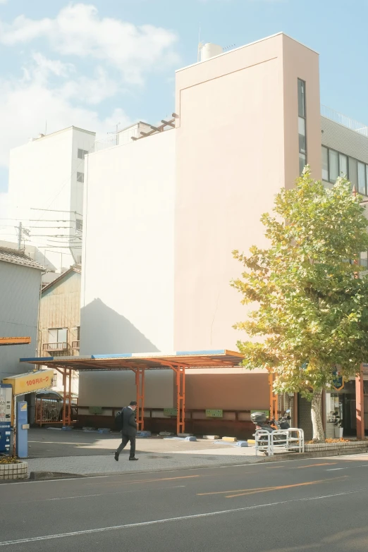 a man walking down a street near a tall building