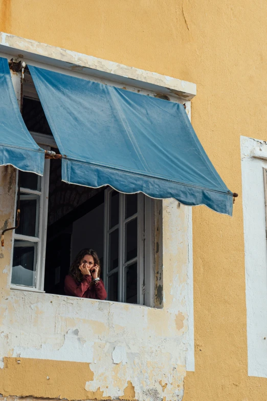 the woman on the phone is looking out the window