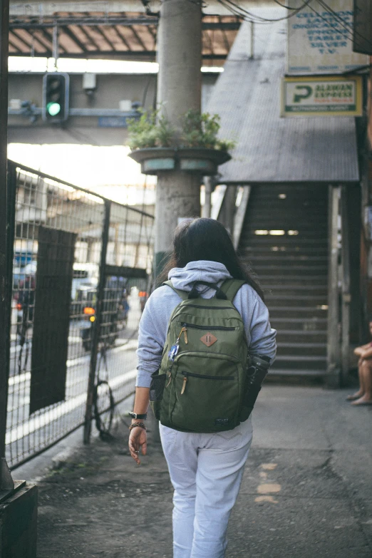 a woman in a backpack walking down a street