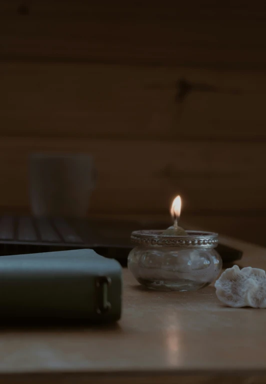 a lit candle that is sitting in a jar