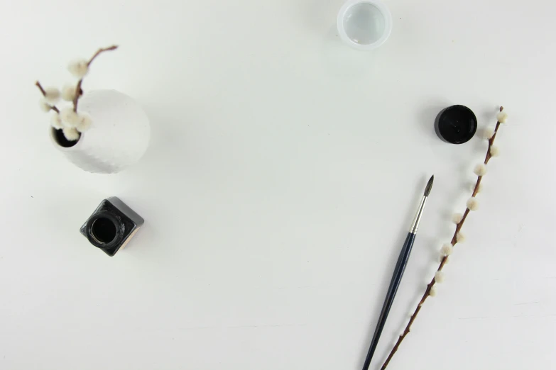 three pens and two jars, one with a pen on top