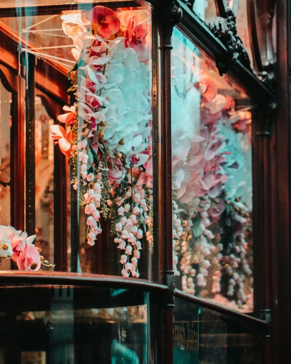 there is a floral arrangement on a rack inside the window