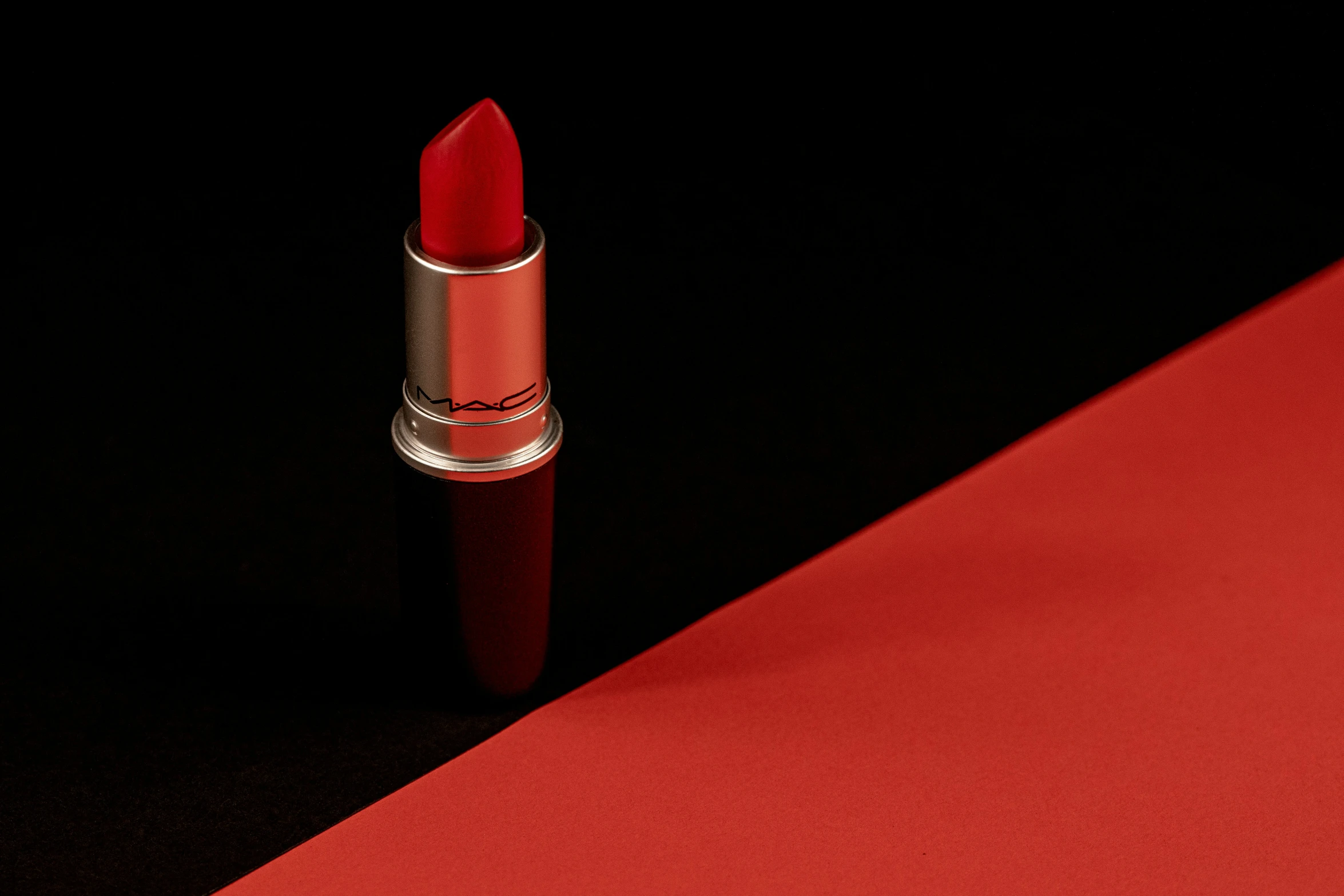 a red lipstick that is on a red mat