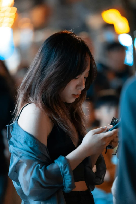 a woman wearing a green shirt looking at her phone