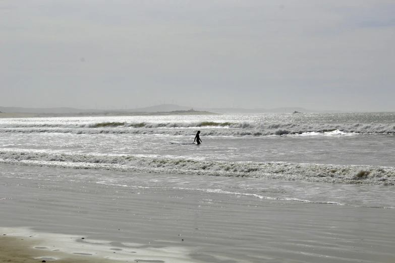 the man is riding a surfboard into the water