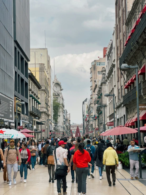 people walk on the sidewalk in a shopping area