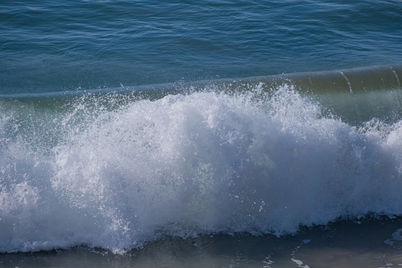 this wave rolls into the shore on the ocean