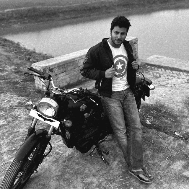 a man leaning on his motorcycle while holding a beer