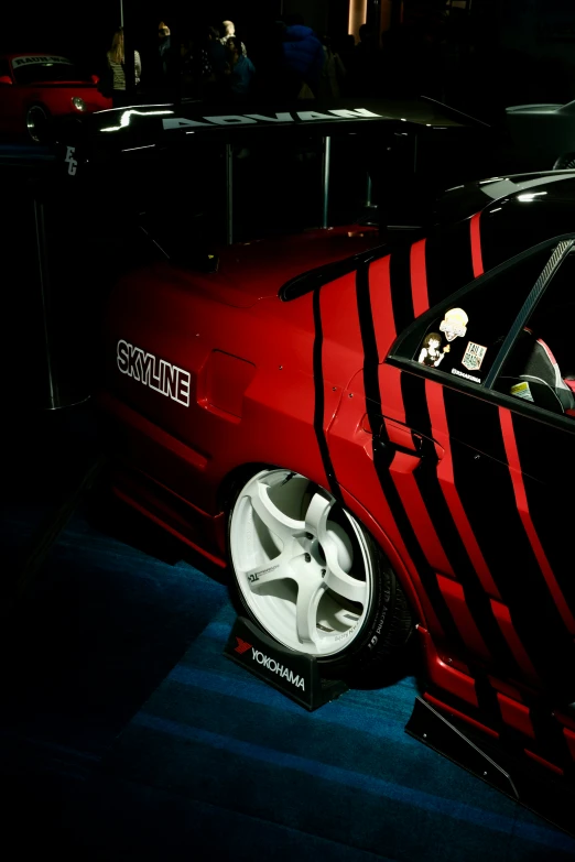 a car with a large wheel and a large red stripe on the hood