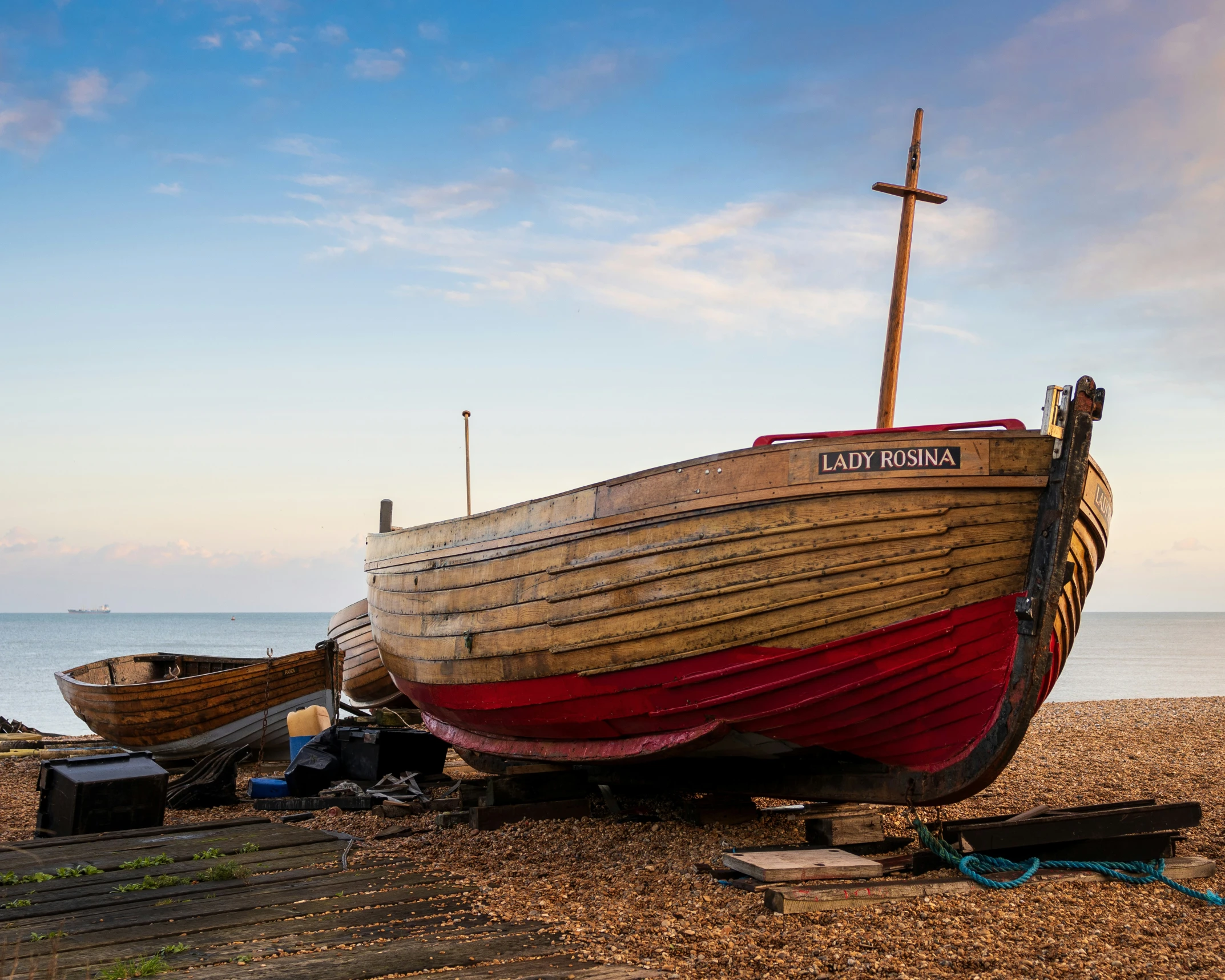 two wooden boats on the beach near water