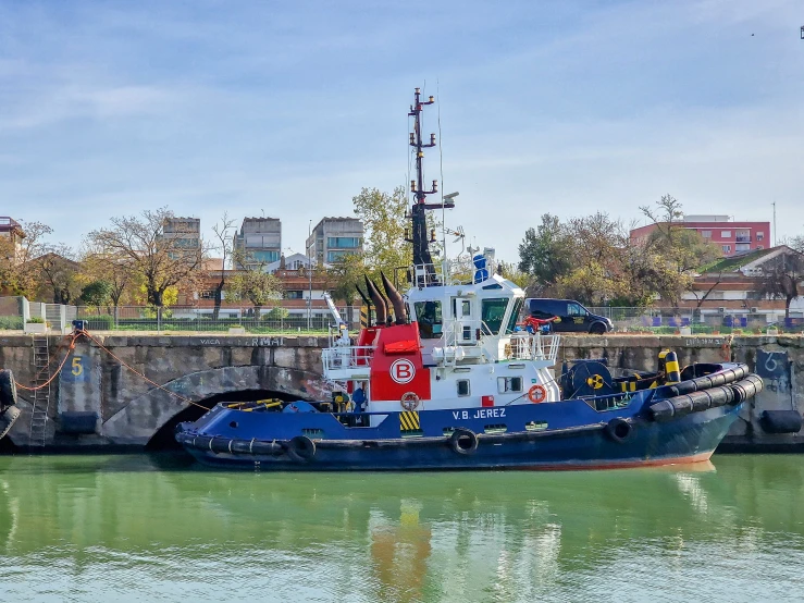 a tug boat is parked near the cement walls