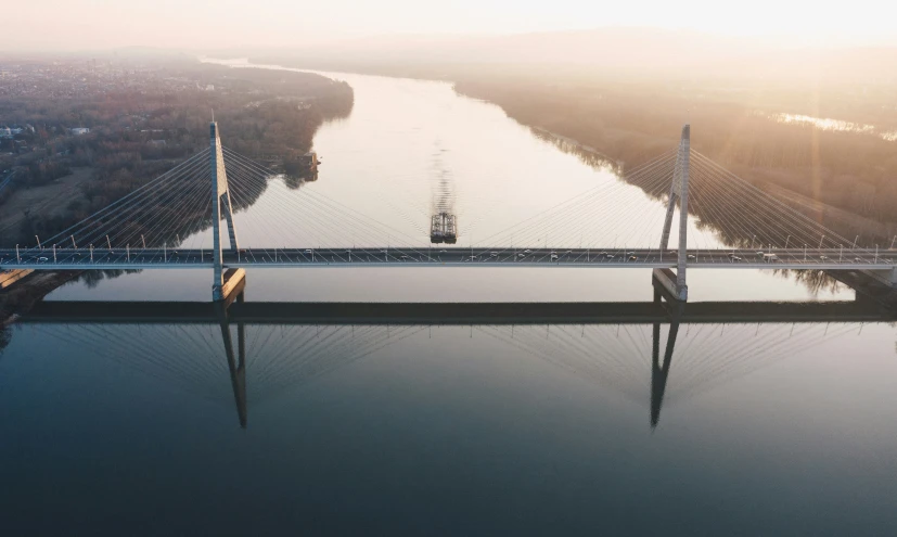 a bridge over a river with a boat going by it