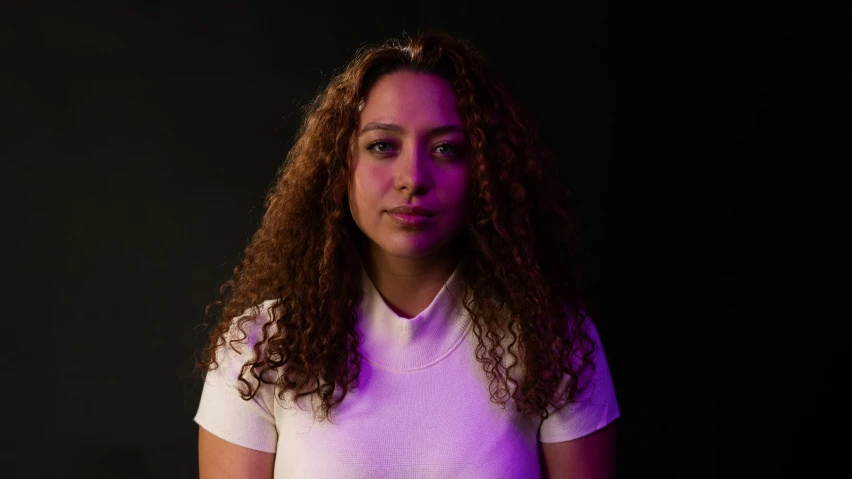 a woman in a white shirt and a purple light