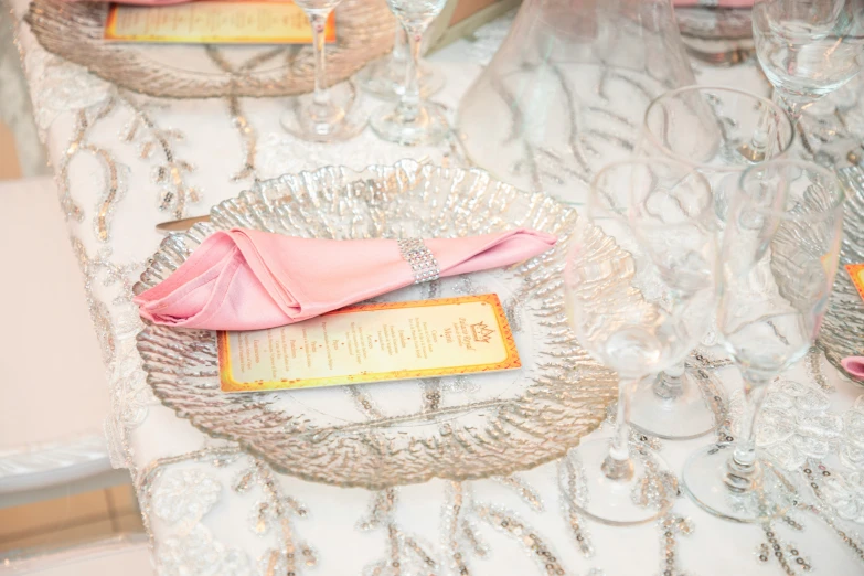 a table with pink napkins on it and place settings