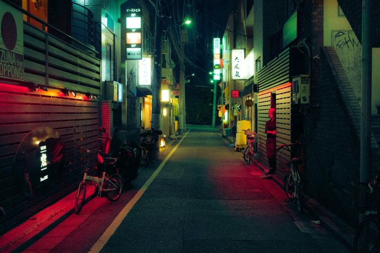 a long narrow alley at night with buildings all lit up