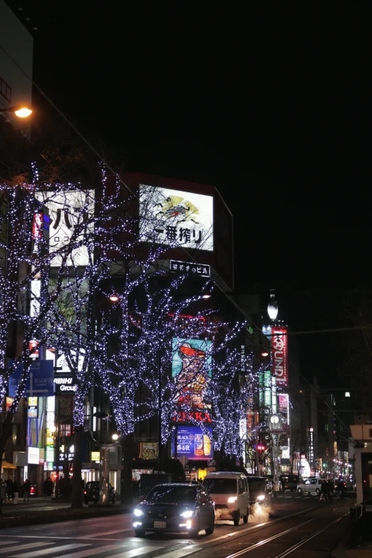 a night view of cars and buildings with lights