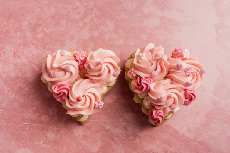 two heart shaped treats are sitting on the surface