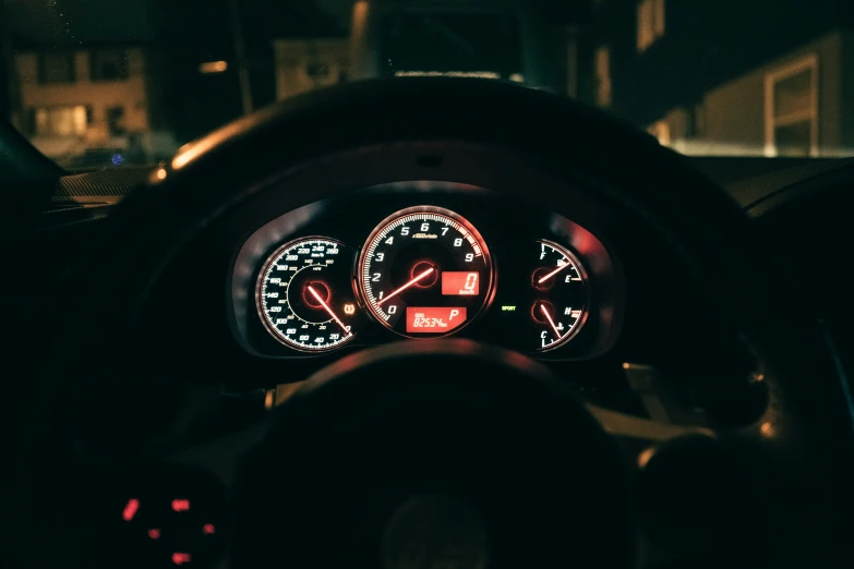 an illuminated dashboard inside of a car on a night